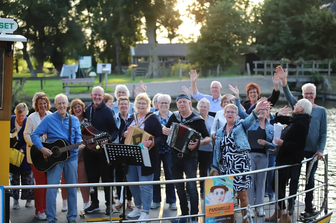 Choir on the pont: Singing from the bank, the café behind them