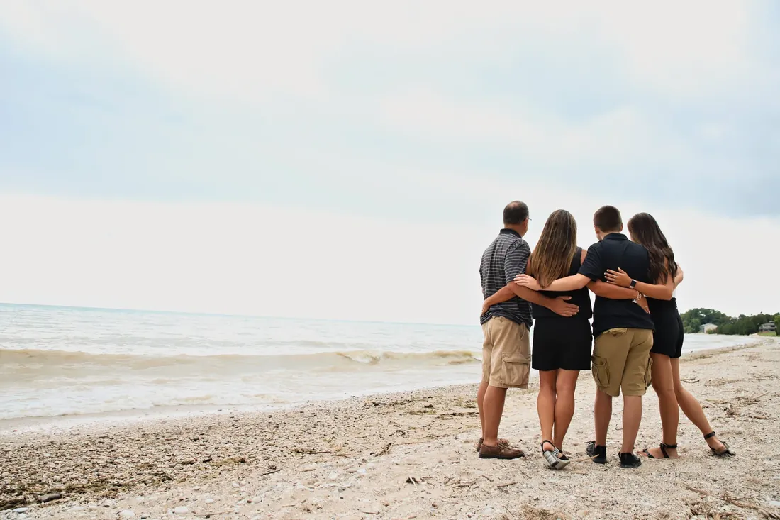 Arms around each other, looking out at the water