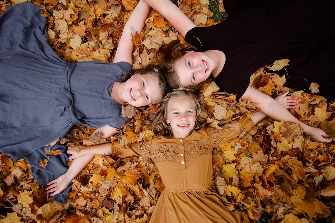 Three sisters lying in the leaves