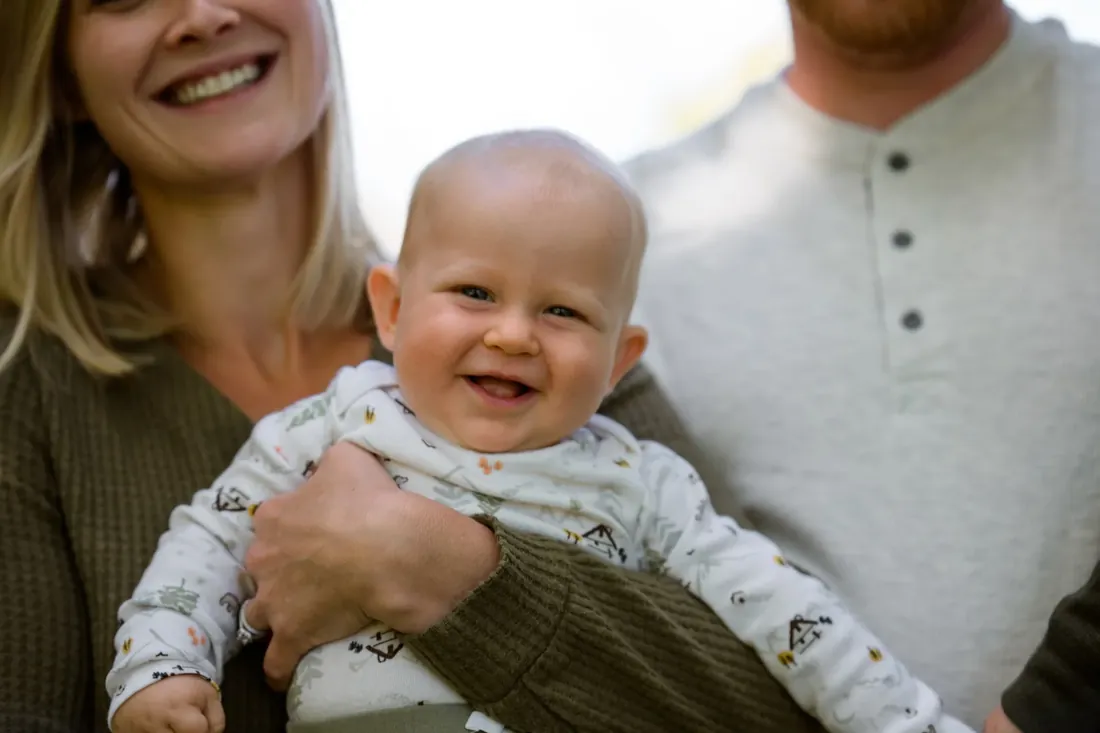 A big grin in mom’s arms