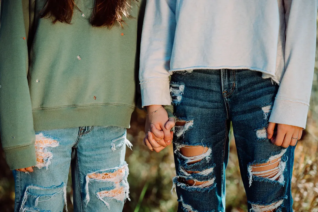 Holding hands in ripped jeans