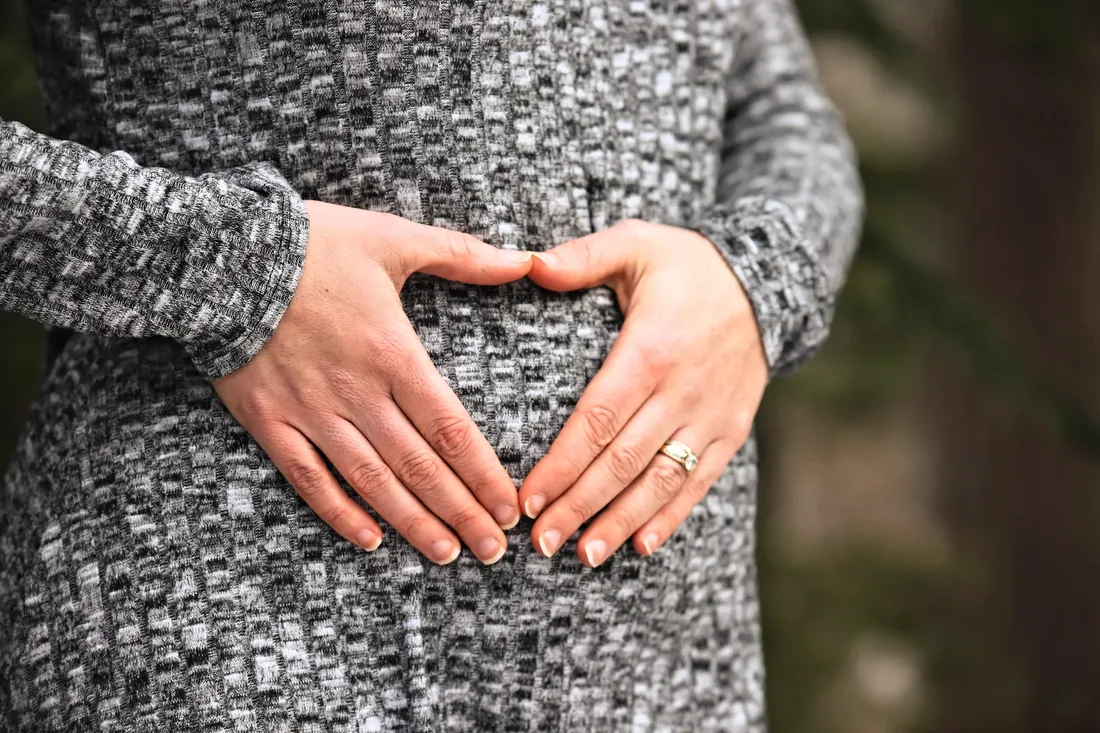 Two hands making a heart over the bump