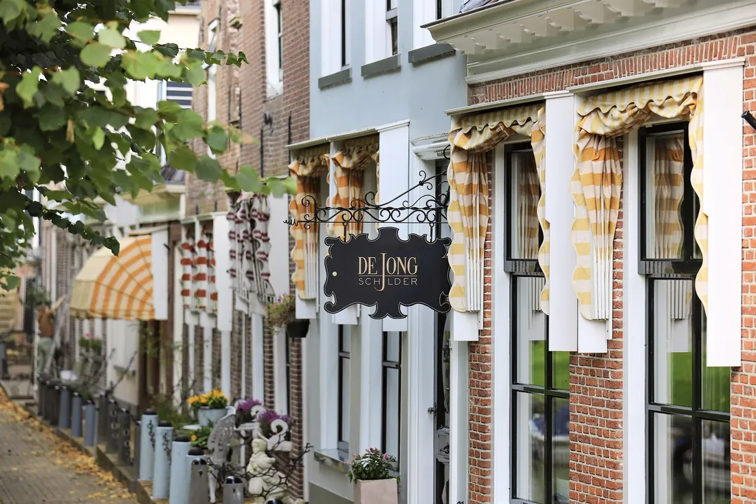 A street of gabled houses and striped awnings