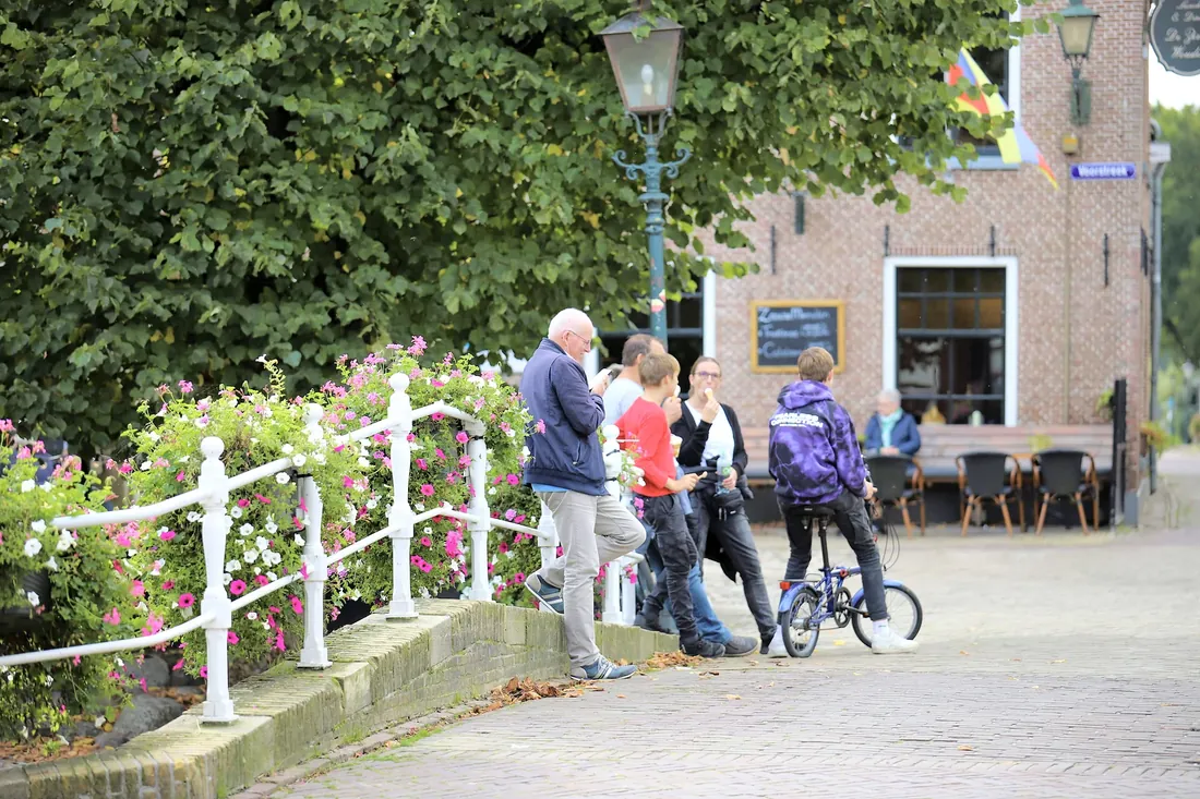 Cyclists stopping on a bridge with white railings