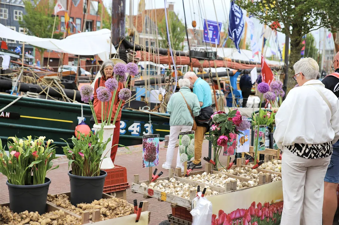 A flower stall on the quay between the tall ships