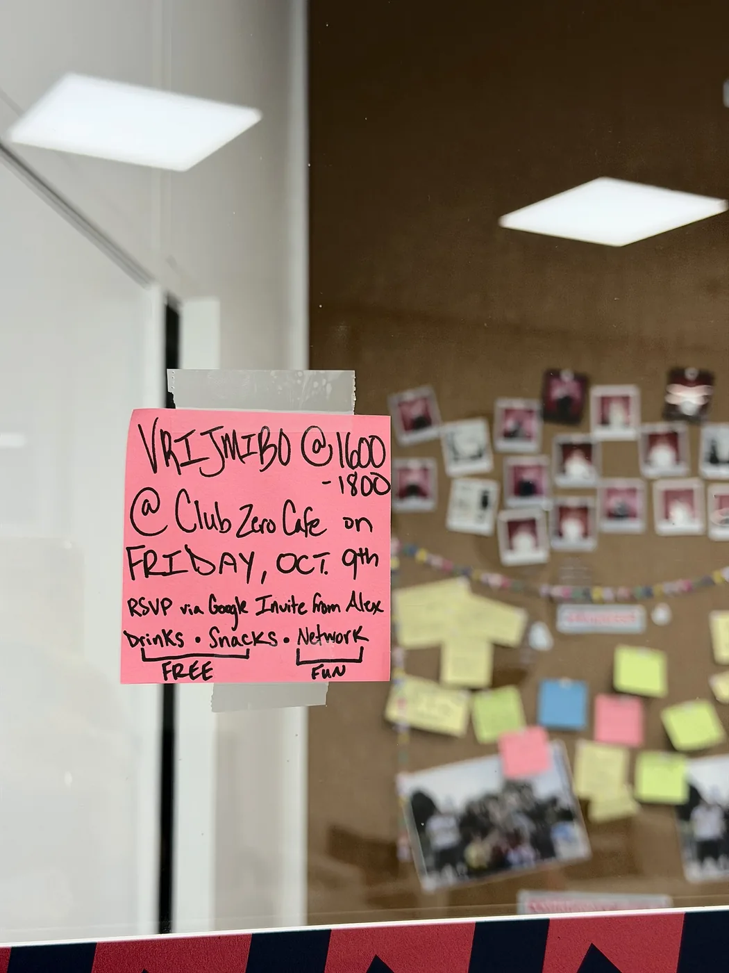 A handwritten pink note on a glass wall: vrijmibo at Club Zero Cafe, Friday 9 October, 16:00 to 18:00