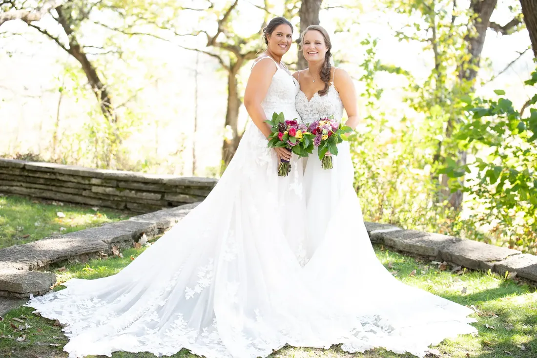 Cece & Erica: two brides and their trains on the stone terrace
