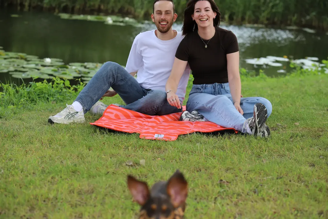 Laughing on the mat while a second dog photobombs