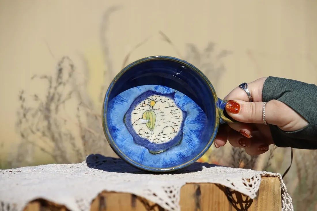 A blue bowl held out over the lace