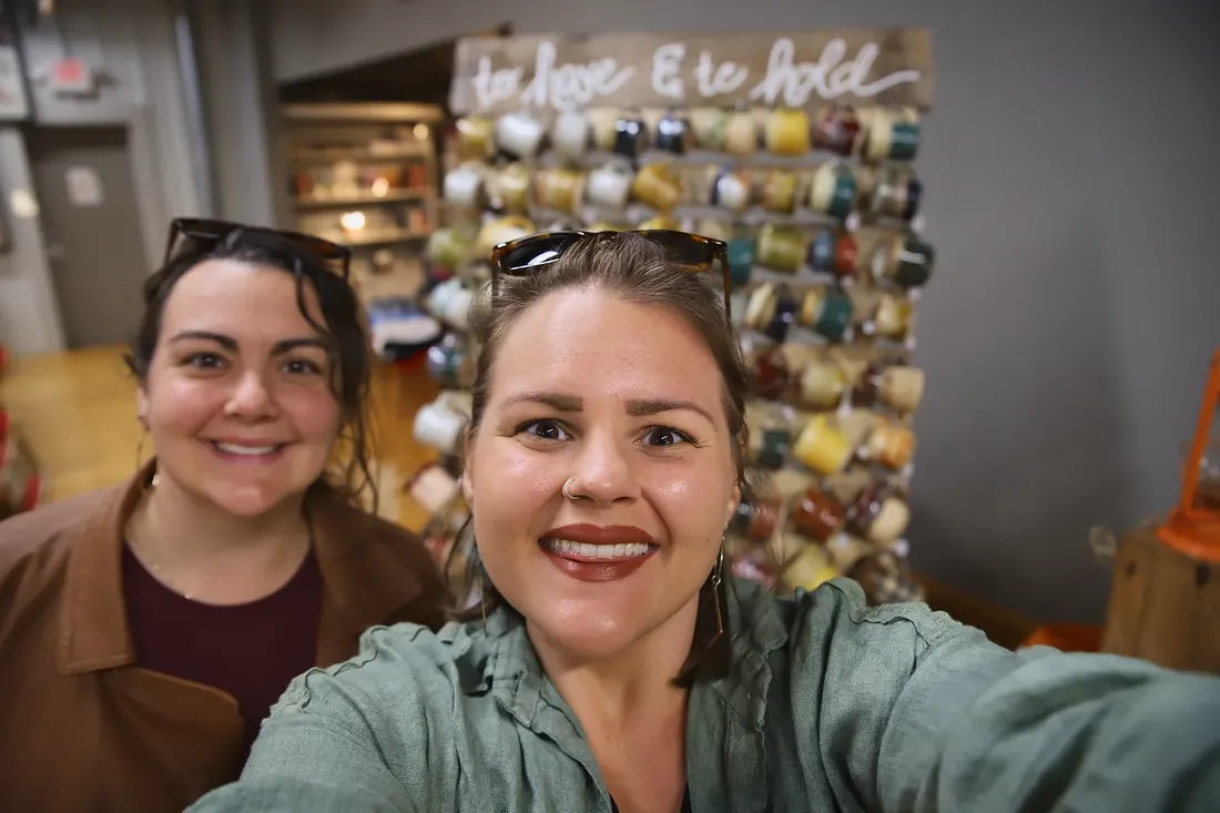 A selfie in front of the mug wall