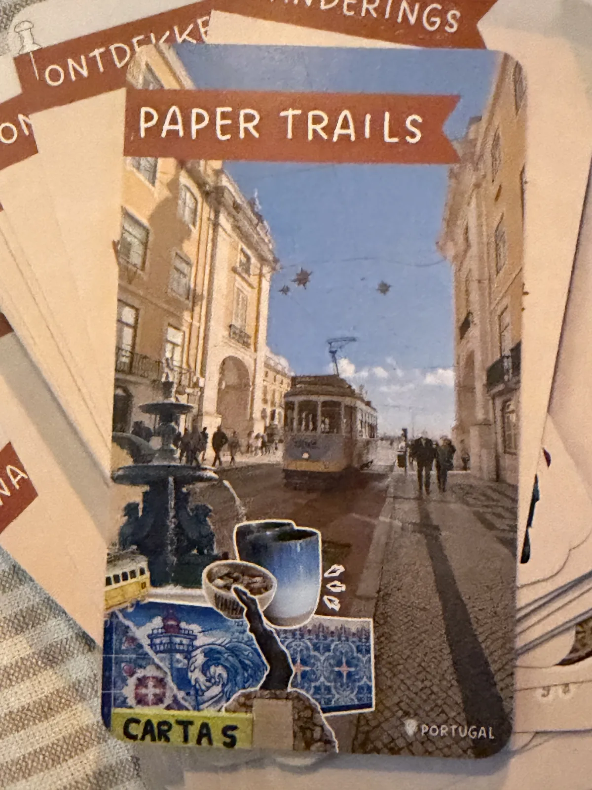 A Paper Trails card front from Portugal: a street with a tram, collaged with blue tiles and a postage stamp
