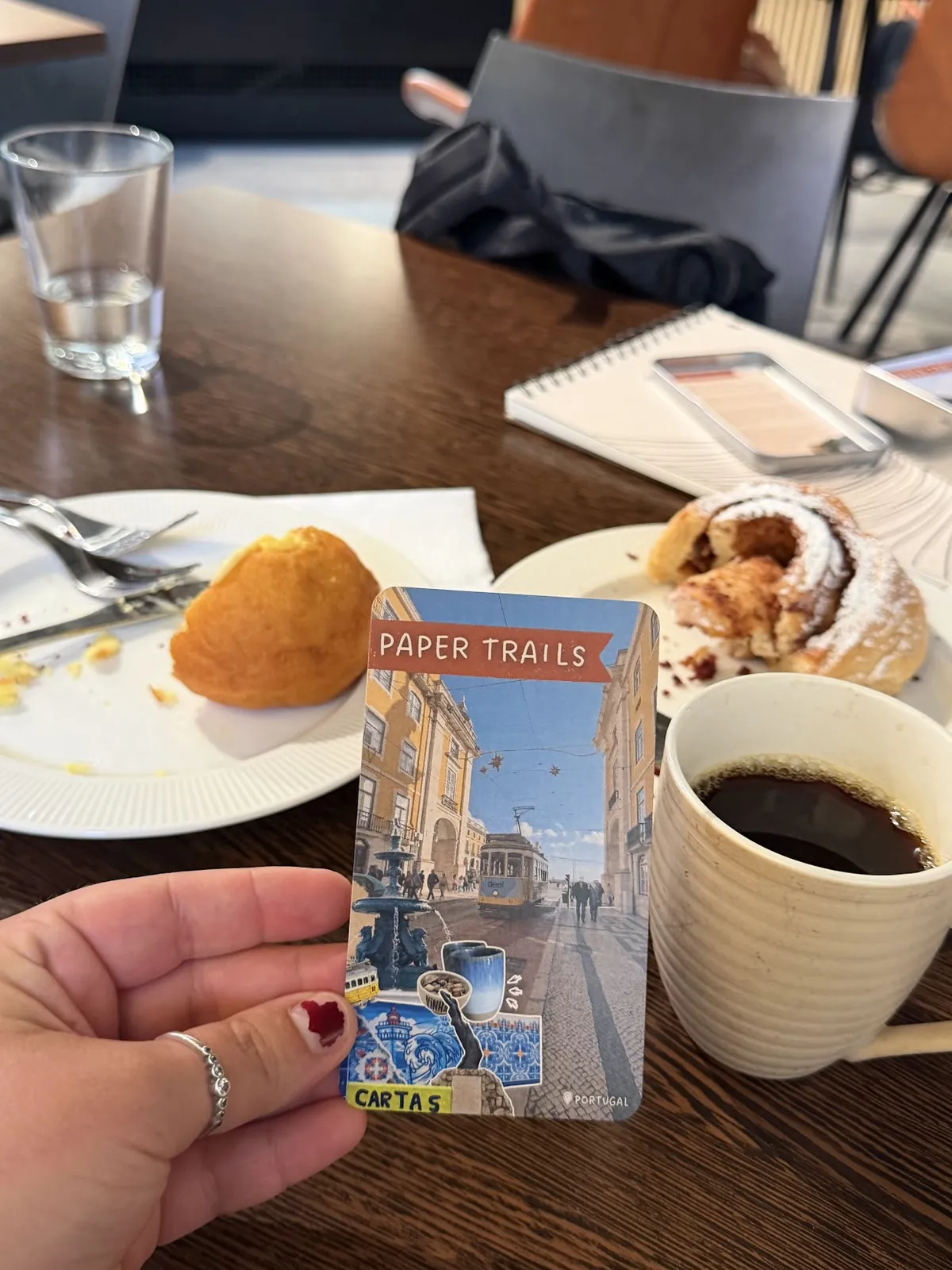 Paper Trails out in the world: at a cafe with coffee, on a canal boat, on a table with tulips, on a rug by candlelight and on a picnic blanket