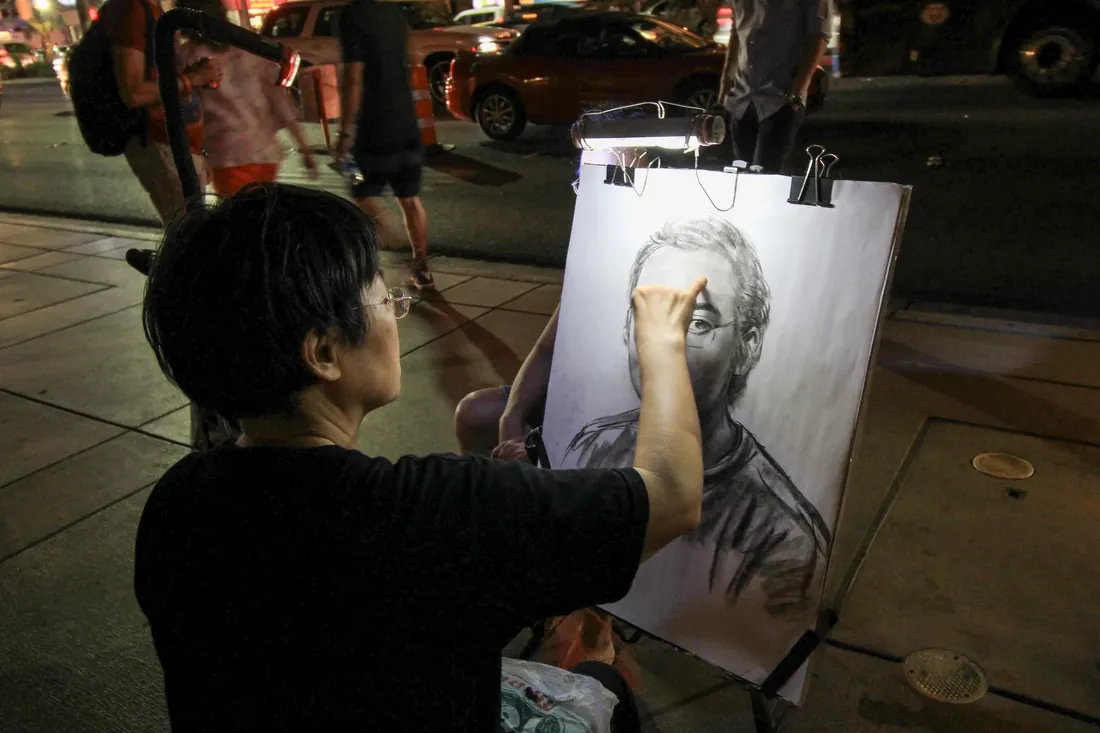 A street artist drawing a portrait at night