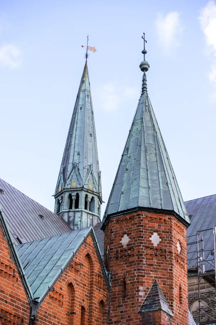 Green spires on a red-brick church