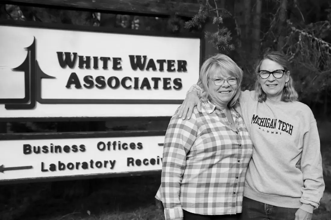 The two of them by the White Water Associates sign