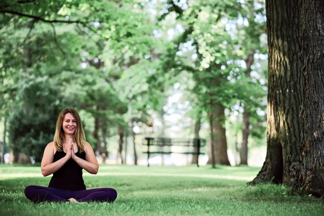 Yoga by the lake: Hands together, sitting in the grass